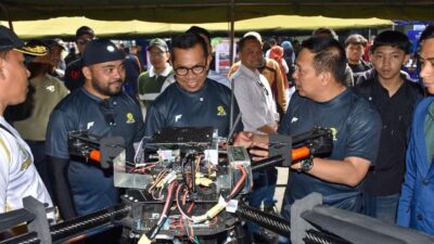 Panggung acara Poltekad Techno Fest 2025 dengan latar pameran teknologi dan komunitas otomotif