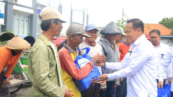 Petugas Lapas Pemuda Madiun menyerahkan paket sembako kepada tukang becak.