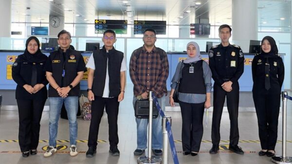 Petugas imigrasi melakukan deportasi WN Malaysia di Bandara Internasional Minangkabau.