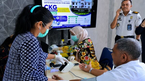 Petugas kesehatan memberikan layanan cek kesehatan gratis kepada pemohon paspor di Kantor Imigrasi Kelas II TPI Belawan.
