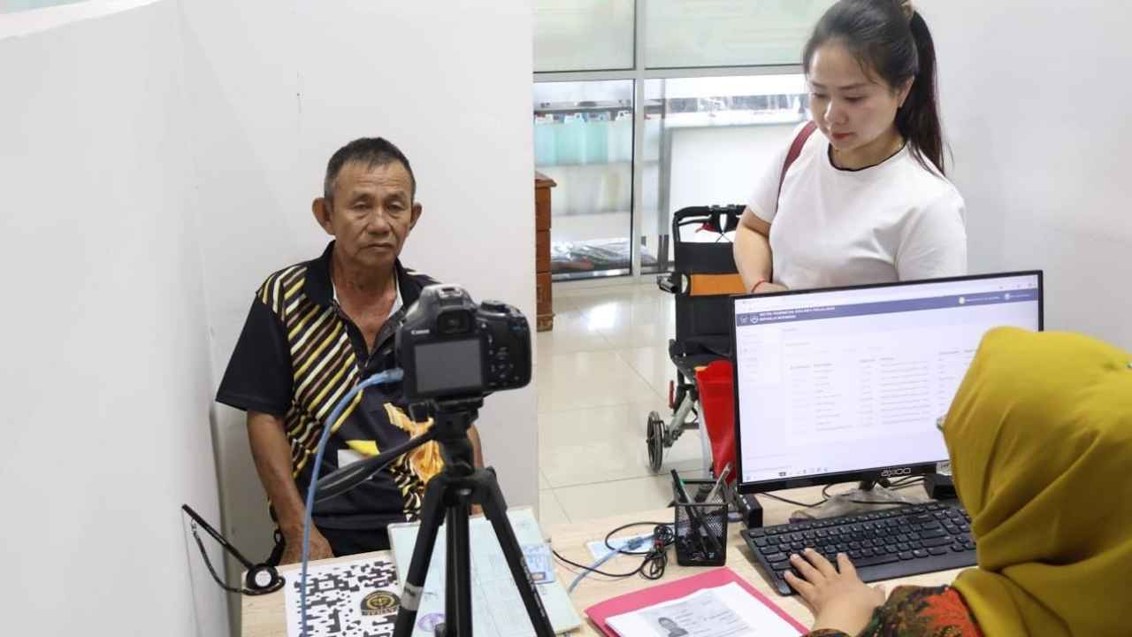 Petugas Kantor Imigrasi Belawan memberikan pendampingan kepada penyandang disabilitas saat mengurus permohonan paspor prioritas.